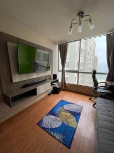 sala de estar con TV de pantalla plana y sofá en Departamento entero super cómodo Airi House N3, en Lima