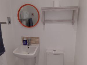 ein weißes Badezimmer mit einem Spiegel und einem Waschbecken in der Unterkunft Corvus - Beautiful cottage half a mile from Mousehole in Penzance + 64 Fotos