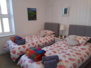 zwei Betten nebeneinander in einem Zimmer in der Unterkunft Corvus - Beautiful cottage half a mile from Mousehole in Penzance
