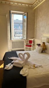 een slaapkamer met een bed met hoeden en een raam bij Piazza Venezia Luxury Suite in Rome