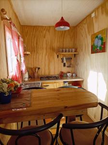 a kitchen with a wooden table and two chairs at Cabañas Aulen Chepu Chiloe in Ancud +12 photos