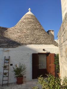 ein weißes Haus mit einem Dach mit einer Leiter in der Unterkunft Trullo al vicoletto al civico 10, civico 8, civico 7 in Alberobello
