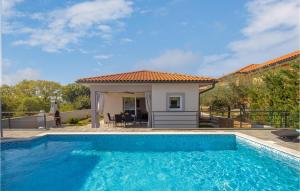 a swimming pool in front of a villa at Nice Home In Kapovci With Outdoor Swimming Pool in Brusići