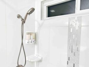 a shower in a bathroom with a tv on the wall at Luxury condo in the heart of Midtown Sacramento in Sacramento