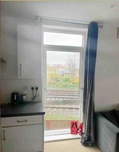 a kitchen with a window and a kitchen counter with a counter at Lovely one bedroom apartment with balcony in Forest Hill