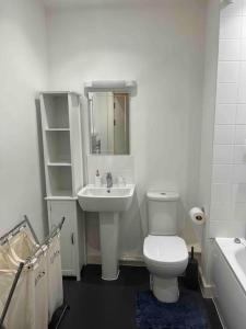 a bathroom with a white toilet and a sink at Lovely one bedroom apartment with balcony in Forest Hill