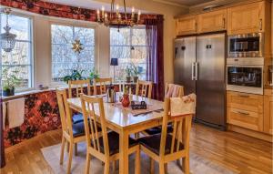 a kitchen with a table and a stainless steel refrigerator at Pet Friendly Home In Rnnng With House Sea View in Rönnäng