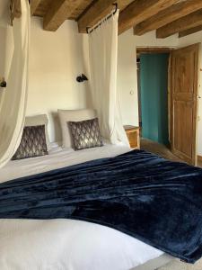 1 dormitorio con 1 cama blanca grande con cortinas en Mercier de Montigny - Les Chambres du Beffroi - SPA et Massage en Fougères