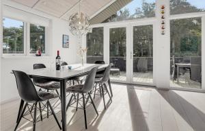 a white dining room with a table and chairs at Stunning Home In Nex With Sauna in Neksø