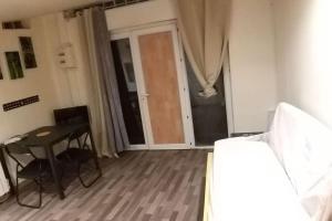 a room with a table and a table and a door at Chambre équipée (proche Paris) in Argenteuil