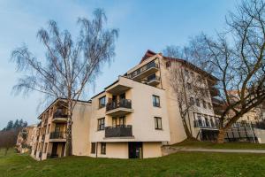 an apartment building with a tree in front of it at Villa Garden Paryski in Olsztyn