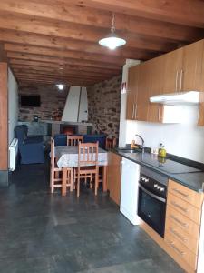 a kitchen and dining room with a table and chairs at O Busto Aldea Rural, Apartamento HORNO 1 in Puebla del Brollón