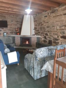 a living room with a couch and a fireplace at O Busto Aldea Rural, Apartamento HORNO 1 in Puebla del Brollón