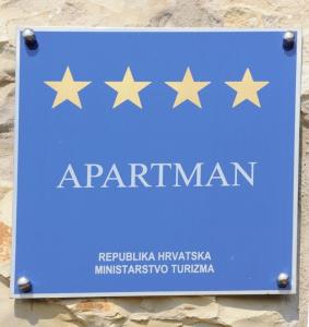a blue sign with five gold stars on it at Apartments Villa Lidija in Kraj