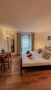 a bedroom with a bed and a desk and a window at B&B ALLA PIAZZETTA DI TEGNA in Tegna