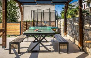 a ping pong table with two benches in a patio at Awesome Home In Omisalj With Kitchen in Omišalj