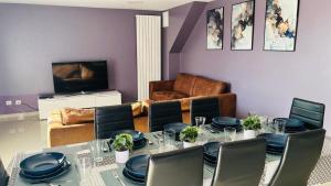 a dining room with a table and chairs and a couch at 100m2 2 chambres 8 personnes - Grand parking et terrasse privée - Proche CDG-Parc expositions-Paris-Astérix-Disney in Villepinte