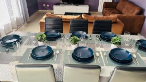 a dining room table with blue dishes on it at 100m2 2 chambres 8 personnes - Grand parking et terrasse privée - Proche CDG-Parc expositions-Paris-Astérix-Disney in Villepinte