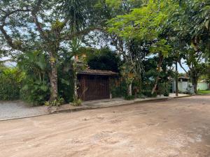a dirt road in front of a house with trees at Itamambuca Suites in Ubatuba