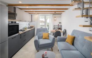 a living room with two blue chairs and a kitchen at Stunning Apartment In Vabriga With Wifi in Vabriga