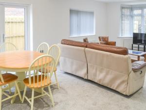 a living room with a couch and a table and chairs at Forest Close in Forest Hall