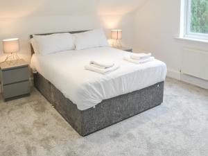 a bedroom with a large bed with two night stands at Forest Close in Forest Hall