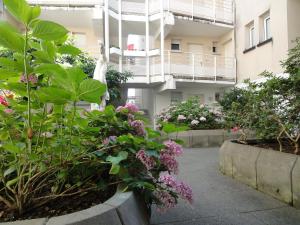 einen Garten vor einem Gebäude mit Blumen in der Unterkunft Kosly garden Robertsau in Straßburg