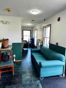 a living room with a blue couch and a table at Attica Inn in Attica