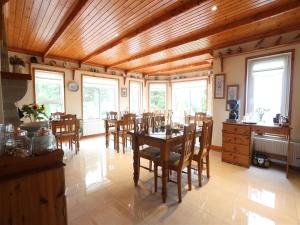 a dining room with a table and chairs and windows at Arches Country House in Donegal