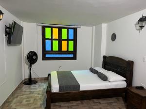 a bedroom with a bed and a stained glass window at Hotel Altana in Cali
