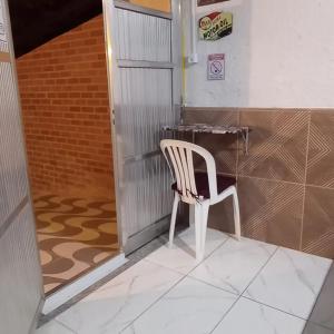 a white chair sitting in front of a desk at Quarto Privado-Suite Aconchego-Miguel Pereira / RJ in Miguel Pereira