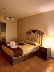 ein Schlafzimmer mit einem Bett mit einem Teddybär drauf in der Unterkunft HOTEL PLAZA PACHUCA in Zapotlán de Juárez