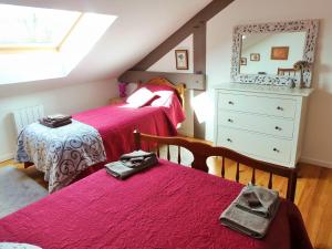 a bedroom with two beds and a dresser and a mirror at La Gicqueliere in Saint-Pair-sur-Mer