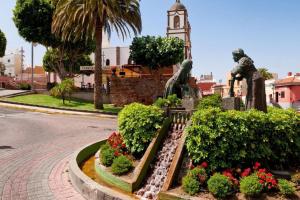 a clock tower in the middle of a street at Viv.Vacacion. Lucía: Apartamento céntrico Ingenio. in Ingenio