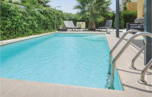 シウダー・ケサダにあるAwesome Home In Ciudad Quesada-rojales With Wifi, Heated Swimming Pool And Swimming Poolの大きな青いスイミングプール(椅子2脚付)
