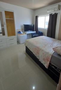 - une chambre avec un grand lit et un bureau dans l'établissement Pé na areia, à Récife