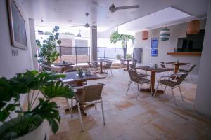 a restaurant with tables and chairs and a large window at Hotel Bella Isa in La Dorada