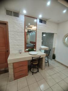 a bathroom with a counter with chairs and a mirror at DEPARTAMENTO ALTOS 4 CERCA DEL CONSULADO in Ciudad Juárez