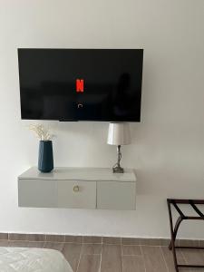a flat screen tv on a white wall at Tramonto Boutique Hotel in La Ceiba
