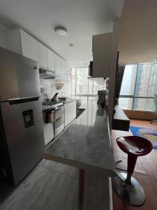 una cocina con armarios blancos y taburete. en Departamento entero super cómodo Airi House N3, en Lima