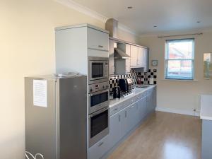 a kitchen with a stainless steel refrigerator and cabinets at 5 Shoreside in Shaldon