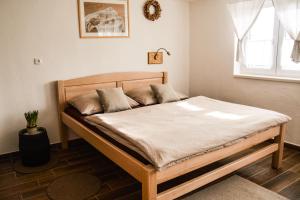 a wooden bed in a room with a window at Vinný sklep in Moravská Nová Ves