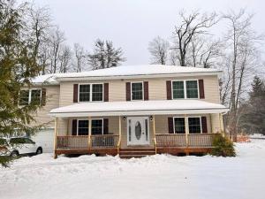 a house with snow on the front of it at Modern 5 Bedroom Pocono house - Jacuzzi - Gameroom - Near Lake - Golf Couse in Tobyhanna