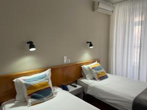 a hotel room with two beds and a window at Hotel Ilha in Angra do Heroísmo