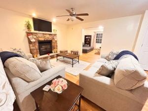 a living room with a couch and a fireplace at Modern 5 Bedroom Pocono house - Jacuzzi - Gameroom - Near Lake - Golf Couse in Tobyhanna