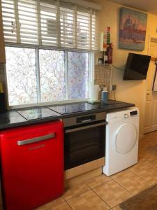 a kitchen with a washing machine and a window at Charming 2 bedroom flat in Canterbury