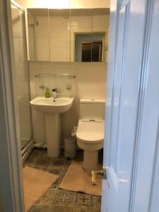 a bathroom with a sink and a toilet and a mirror at Charming 2 bedroom flat in Canterbury