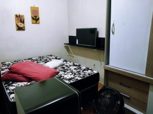 um pequeno quarto com uma cama e uma ventoinha em Casa Excelente Localização! em Rio Grande