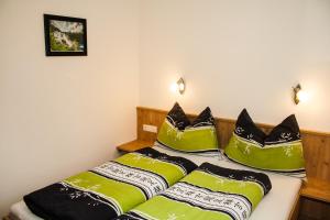 a bedroom with a bed with green and black pillows at Apartment Valentina in Neustift im Stubaital