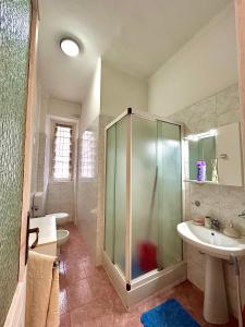 La salle de bains est pourvue d'une douche en verre et d'un lavabo. dans l'établissement Bella House, a 200 metri dalla metropolitana, à Turin